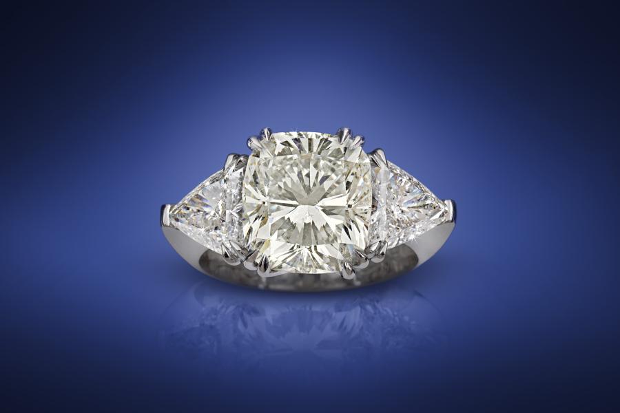 Diamantring, zus. ca. 7,57 ct, Diamant im Cushionschliff 5,77 ct, zwei Diamanten im Trillionschliff, zus. ca. 1,80 ct. Schätzwert € 100.000 - 150.000