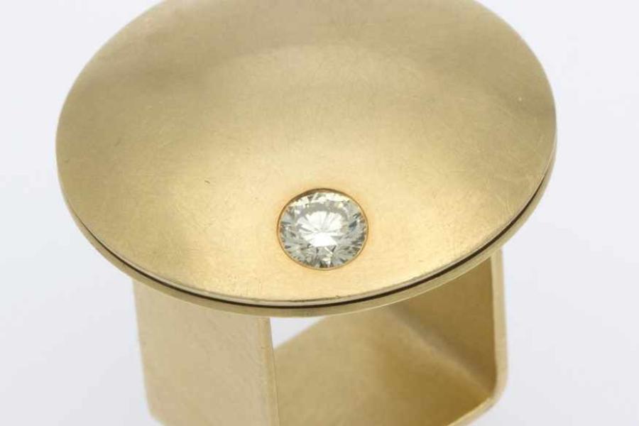 Kinetischer Brillant-Ring "Sternschnuppe" von Barbara Schulte-Hengesbach Gelbgold 750, gebürstet. Runder pilzförmiger Ringkopf, ausgefasst mit 1 Brill. ca. 0,55 ct, Getönt/VS-SI. Firmensignet: S-H. RG 52. Ca. 30,9 g. Aufrufpreis:	1.300 EUR