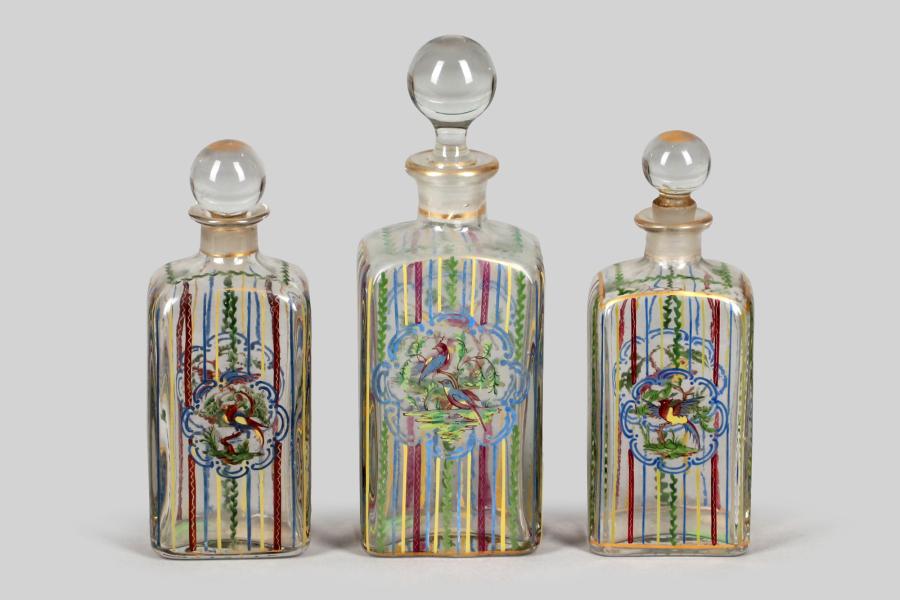 00012 Drei Parfumflacons, Frankreich, 19.Jh.  ‚Paradiesvögel‘, polychrome Emaillemalerei, Boden mit Verkäufersignatur Damon & Delente, Paris, H = 18 cm (2) und 20 cm, berieben, Stöpsel innen bestoßen  Ausruf€ 100,–