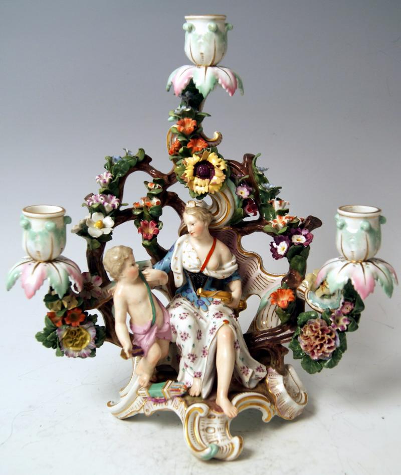 Kerzenleuchter Meissen Porzellan, farbig bemalt Mädchen mit Putto, umrankt von Blüten und Blättern Meissen um 1860 Höhe: 32 cm   Zur Verfügung gestellt von: city-antik / Kunsthandel