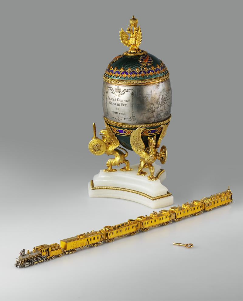 Osterei mit dem Modell eines Sibirien-Zuges (659 KB) Geschenk von Zar Nikolaus II. an die Zarin Alexandra Fjodorowna zum Osterfest des Jahres 1900 Sank Petersburg, 1900 Firma: C. Fabergé, Meister: M. Perchin Gold, Platin, Silber, teilweise vergoldet, Diamanten in Rosenschliff, Rubin, Onyx, Kristall, Holz, Seide, Samt, Email auf guillochiertem Grund, Filigran- Email Ei: H. 26 cm, Zug: L. 39,8 cm, Waggon: H. 2,6 cm © The Moscow Kremlin State Historical and Cultural Museum and Heritage Site