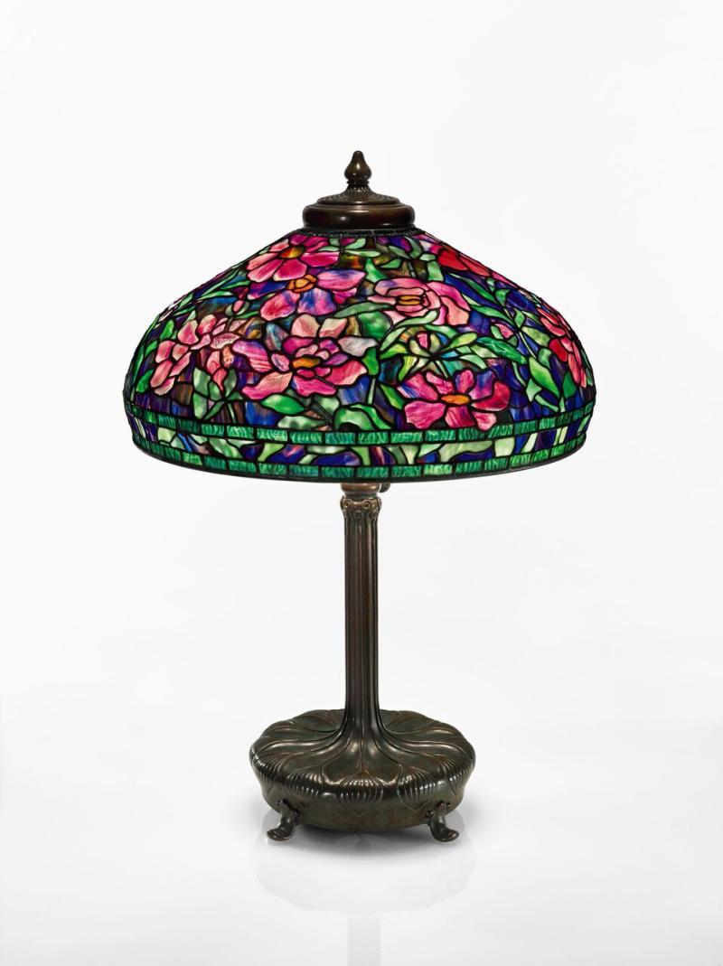 Lot 34 Property From The Collection Of David And Lindsay Morgenthaler, Cleveland, Ohio Tiffany Studios "Peony" Table Lamp with a telescopic "Chased Pod" library standard base shade impressed TIFFANY STUDIOS NEW YORK 1505-36 base impressed 9933/TIFFANY STUDIOS/NEW YORK with the Tiffany Glass and Decorating Company monogram leaded glass and patinated bronze  32 1/2  in. (82.6 cm) high as shown 22 in. (55.9 cm) diameter of shade circa 1910 Est. $180/240,000 Sold for $ 225,000