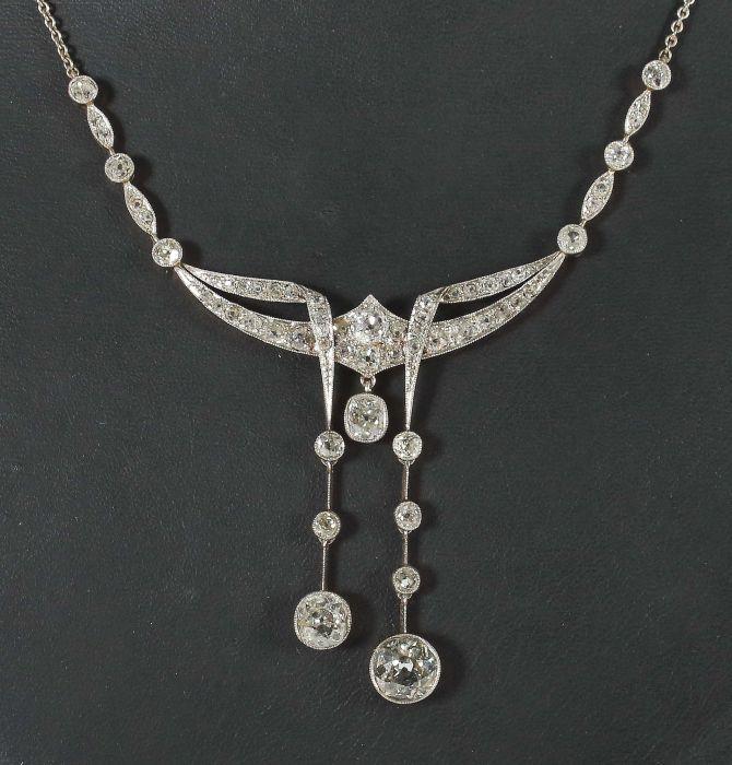 Exquisites Art-Déco Collier 1920/30er Jahre, Platin/Gelbgold 750, geometrisch anmutendes, durchbrochen gearbeitetes Mittelstück, besetzt von zahlreichen Diamanten sowie mit angehängten, gefassten Diamanten, je im Altschliff, der größte hiervon ca. 1,25 ct (58 Diamanten, zus. ca. 5,6 ct, Mindestpreis:	15.000 EUR