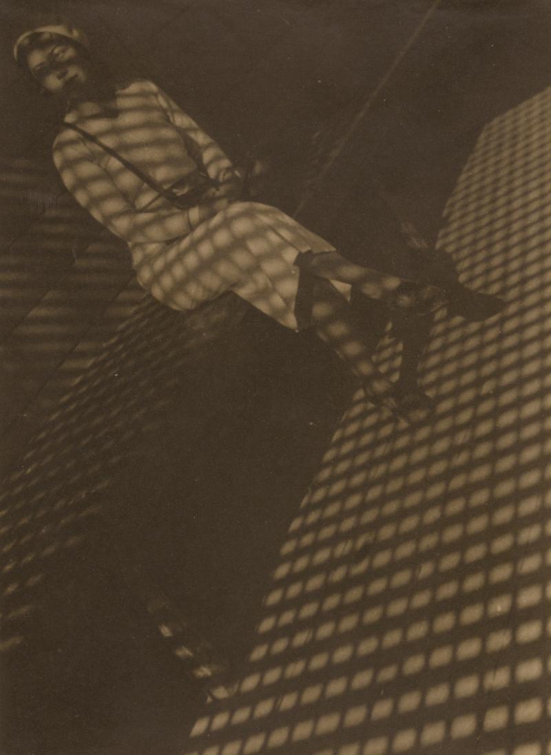 Lot 131 Aleksandr Rodchenko Girl With A Leica (Devushka S Leikoi) large-format, toned, credited, titled in Cyrillic, dated, and '26' [circled], possibly by the photographer's daughter, Varvara Rodchenko, in pencil and the Rodchenko/Stepanova collection stamp on the reverse, tipped to a buff paper mount, signed, with '36' and '1936,' and annotations in Cyrillic in pencil, credited, titled in Cyrillic, dated, and '26' [circled], possibly by the photographer's daughter, Varvara Rodchenko, in pencil