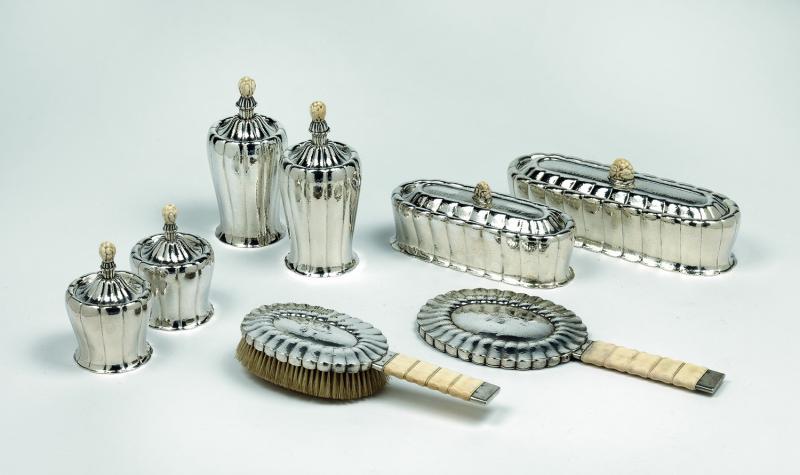 Otto Prutscher, achtteiliges Toiletteset, Wiener Werkstätte um 1920, Silber, reliefiert, geschnitztes Elfenbein Schätzwert € 50.000 – 80.000