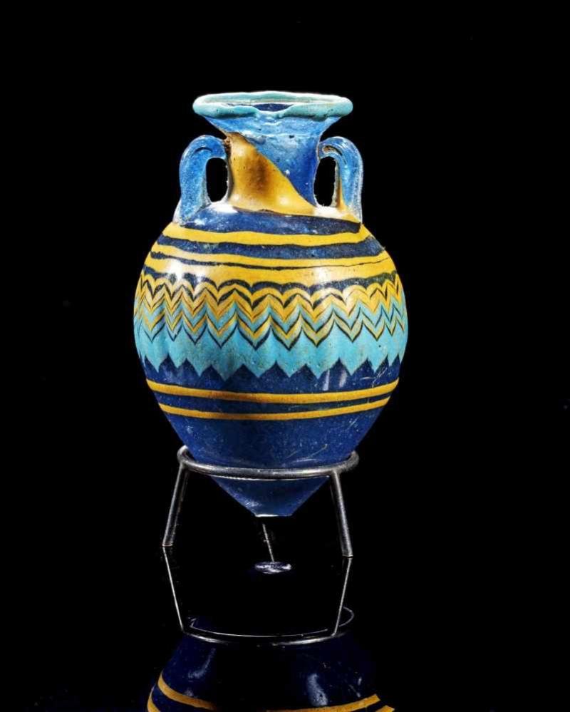 Amphoriskos in Sandkerntechnik. Östliches Mittelmeergebiet, 6. - 5. Jh. v. Chr. H 8cm. Kleines apfelförmiges Gefäß aus blauem Klarglas mit kurzem zylindrischen Hals Aufrufpreis:	1.200 EUR Schätzpreis:	1.500 EUR