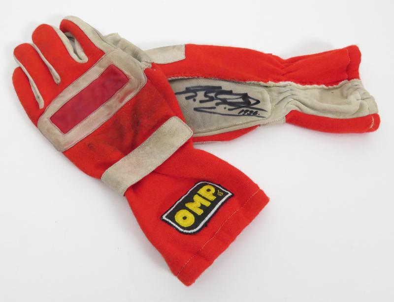 Nr. 28 Ferrari "OMP" Rennhandschuhe/Racing Gloves" von Michael Schumacher signierte OMP Rennhandschuhe, Innenfutter beschriftet und datiert: G. P. Spain 02.06.96, beide Handflächen vom 7-fachen Weltmeister signiert und datiert 1996, Handrücken mit verwaschener Signatur OMP-Aufnäher, gebraucht, guter Zustand Startpreis € 600