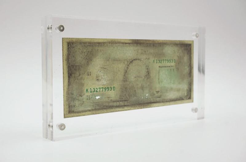 Agustina Woodgate, K13277993D, 2021. 12 cm x 22 cm x 1.5 cm, Hand-sanded $1 US banknote in acrylic case. Courtesy of the artist and Barro