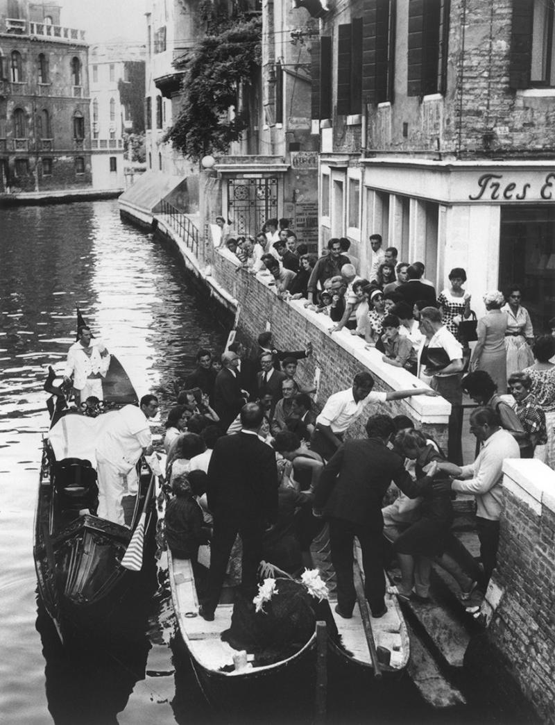 L'Enterrement de la Chose de Tinguely, Beim Besteigen der Gondeln: Harold Acton, Peggy Guggenheim, Ernst Von Leyden. In den Gondeln stehend, von hinten: Frank Amey und Jean-Jacques Lebel. Am Ufer: Nikki Amey, Guy Harloff und seine Frau, Arbit Blatas und andere, 1960  ©Cameraphoto Venezia, The Getty Research Institute, Research Library, Fonds Allan Kaprow /  Archives Lebel