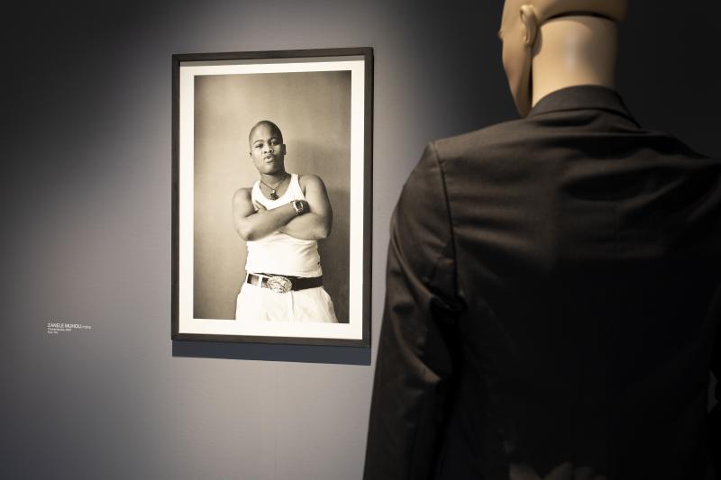 Thembi Nyoka“ (2007) aus Zanele Muholis Fotoserie „Faces & Phases“, in der die Künstlerin von 2006 bis 2016 die schwarze LGBTQIA-Bewegung in Südafrika dokumentiert. Im Vordergrund ist die Schaufenster-puppe aus Richard Hoecks „Untitled“ (2021) zu sehen. Copyright: Maria Kirchner